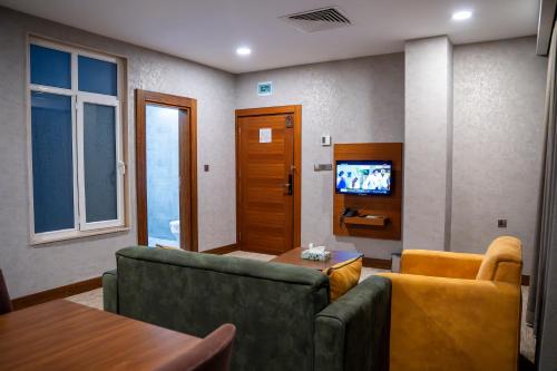 a living room with a couch and a tv at Parwar Hotel in Duhok