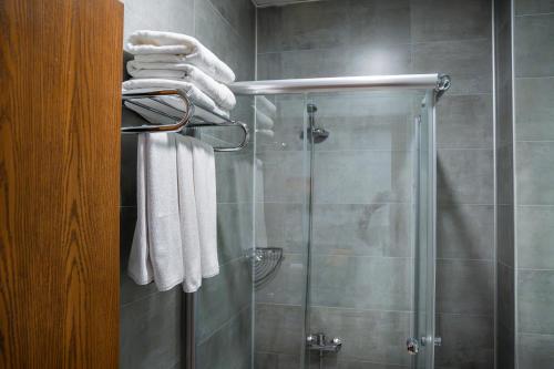 a bathroom with a shower with white towels at Parwar Hotel in Duhok