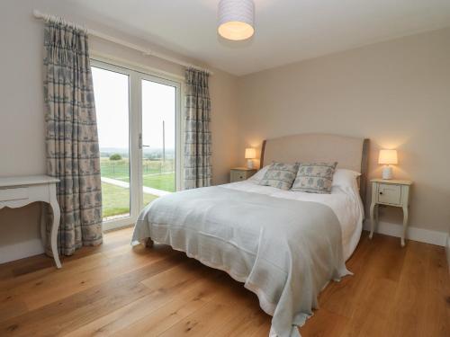 um quarto com uma cama e uma grande janela em Cotswold View em Chipping Norton