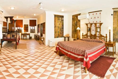 a bedroom with a bed and a desk in a room at Neemrana's - Tijara Fort Palace in Alwar