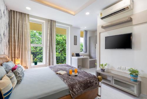 um quarto com uma cama grande e uma televisão em Homlee-3bhk Green Luxury in SDEL em Nova Deli