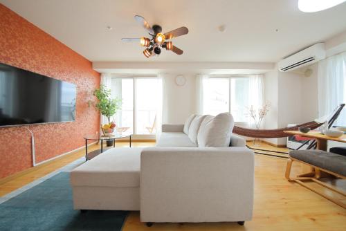 a living room with a white couch and a ceiling fan at AMS TOWER 2101 in Sapporo