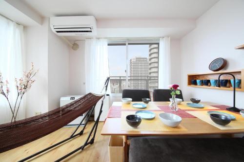 a dining room with a wooden table and a hammock at AMS TOWER 2101 in Sapporo