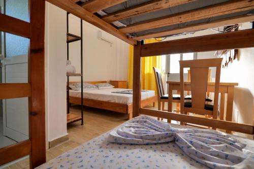 a bedroom with two bunk beds and a dining room at Tropikal Freskia Bunec in Sarandë