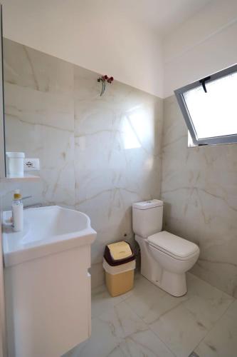 a white bathroom with a toilet and a sink at Tropikal Freskia Bunec in Piqeras