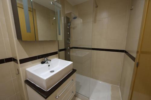 un bagno bianco con lavandino e doccia di Apartamento con vistas al mar y montaña a Oropesa del Mar