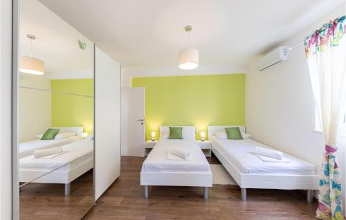 ein Krankenhauszimmer mit 2 Betten und einem Spiegel in der Unterkunft Gorgeous Home In Mravince With Wifi in Mravince
