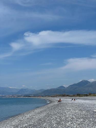 a group of people sitting on a beach near the water at Ascensore per la spiaggia in Cirella