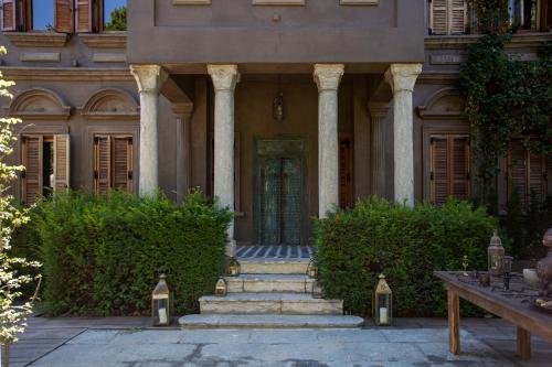 an entrance to a building with columns and a door at Life Gallery Hotel & Spa in Korçë
