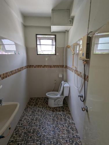 a small bathroom with a toilet and a sink at Alongkon Mansion in Sakon Nakhon