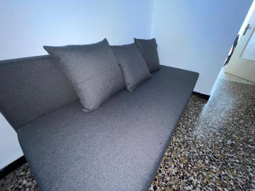 a couch with four pillows on the floor at La Finestra su Savona, Appartamento Centrale in Savona