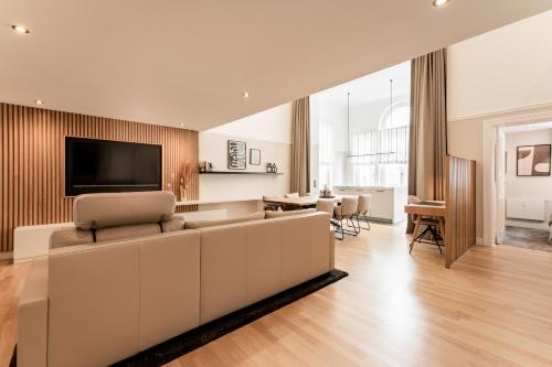 a living room with a large couch and a television at Strandhotel Kurhaus Juist in Juist