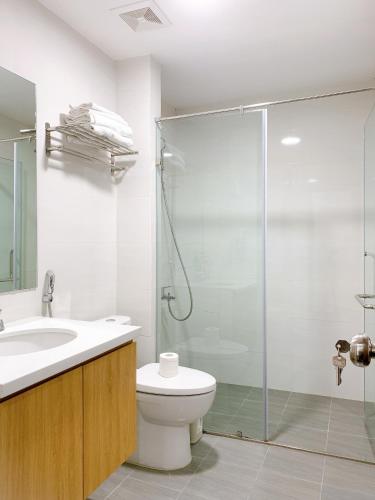 a bathroom with a toilet and a glass shower at TSQ STAY Hotel Apartment in Hanoi
