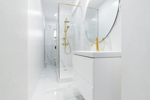 a white bathroom with a sink and a mirror at Opera in Bytom