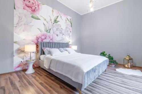 1 dormitorio con 1 cama y papel pintado con motivos florales en Opera, en Bytom