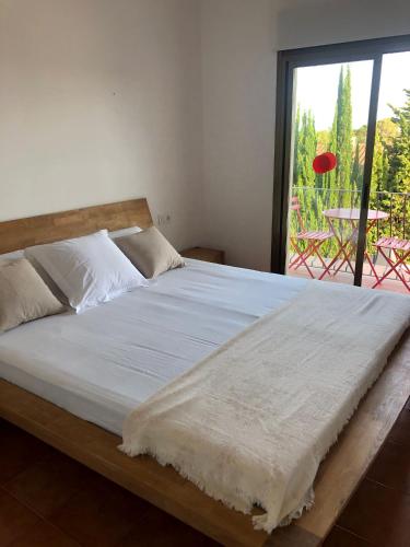 a large bed in a room with a window at Kalma House in Torroella de Montgrí