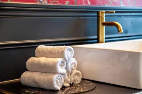 uma pilha de toalhas numa mesa ao lado de uma banheira em Prestige 2 Bedroom Apartment With Free Parking em Bournemouth
