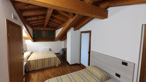 1 dormitorio con 2 camas y techo de madera en Wine Resort en Faedis