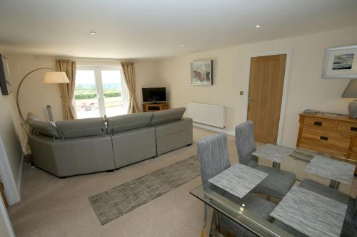 ein Wohnzimmer mit einem Sofa und einem Tisch in der Unterkunft Lovely two bedroom bungalow with hot tub in Yeovil