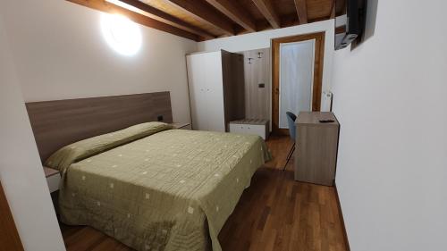 a bedroom with a bed and a wooden floor at Wine Resort in Faedis