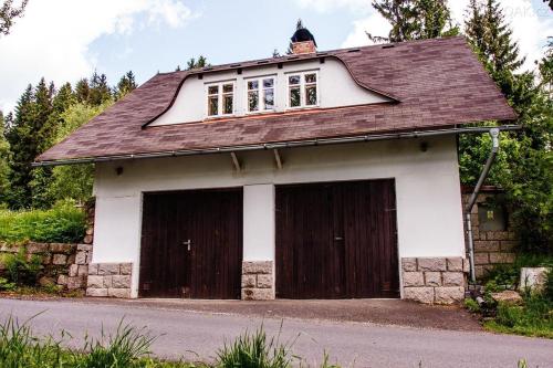 un garaje con dos puertas marrones y blancas en Chata Sedmidomí, en Lučany nad Nisou