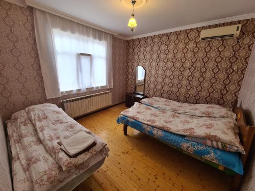 1 Schlafzimmer mit 2 Betten und einem Fenster in der Unterkunft Nasimi Villa in Qəbələ