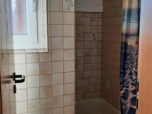 ein Bad mit einer Badewanne und einer Dusche mit einem Fenster in der Unterkunft Ferienwohnung Klute in Allendorf