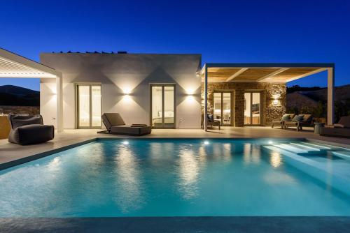 a swimming pool in front of a villa at Villa Solevara - luxury villa with Infinity Pool, jacuzzi, cinema room & luxury amenities in Aspro Chorio Paros