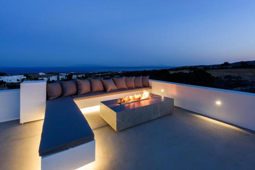 a living room with a couch and a fire pit at Villa Solevara - luxury villa with Infinity Pool, jacuzzi, cinema room & luxury amenities in Aspro Chorio Paros
