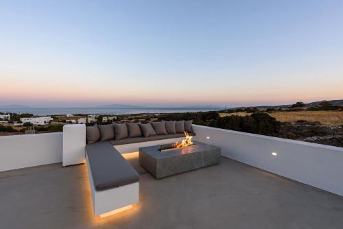 a living room with a couch and a fire pit at Villa Solevara - luxury villa with Infinity Pool, jacuzzi, cinema room & luxury amenities in Aspro Chorio Paros