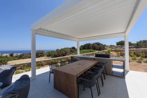 a pavilion with a table and chairs on a patio at Villa Solevara - luxury villa with Infinity Pool, jacuzzi, cinema room & luxury amenities in Aspro Chorio Paros