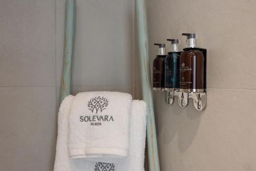 a bathroom with a towel and two bottles of soap at Villa Solevara - luxury villa with Infinity Pool, jacuzzi, cinema room & luxury amenities in Aspro Chorio Paros