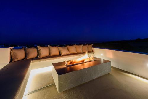 a fire pit on the side of a balcony at night at Villa Solevara - luxury villa with Infinity Pool, jacuzzi, cinema room & luxury amenities in Aspro Chorio Paros