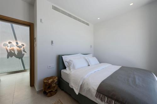 a bedroom with a large bed with white sheets at Villa Solevara - luxury villa with Infinity Pool, jacuzzi, cinema room & luxury amenities in Aspro Chorio Paros