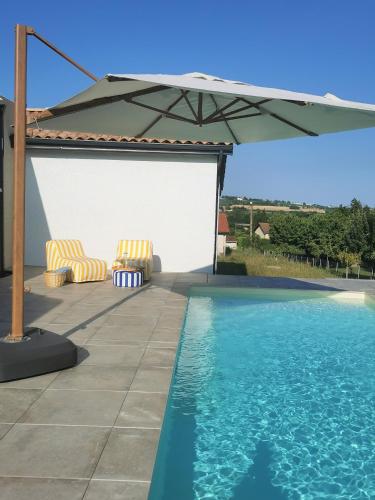 un patio avec un parasol et une piscine dans l'établissement Au Jardin des Deux Roches, à Prissé