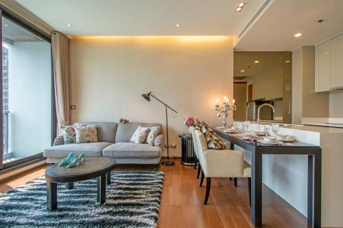 a living room with a couch and a table at Luxury 1BR 300m BTS PhromPhong, Empo, EmQ, EmSphere, Rooftop Pool, Gym, Fast 500mbps wifi in Bangkok