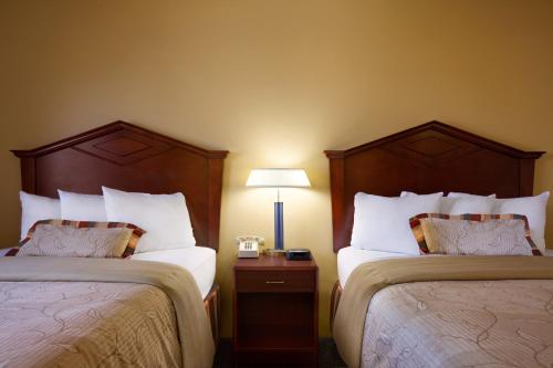 a hotel room with two beds and a lamp at Days Inn by Wyndham Austin in Austin