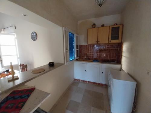 una cucina con mobili bianchi e un piano di lavoro di Tamalou Djerba a Midoun