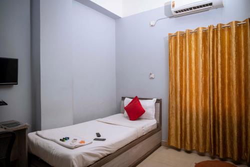 een slaapkamer met een bed met een geel gordijn bij Hotel Town and country inn ( a unit of GS RESIDENCY) in Guwahati