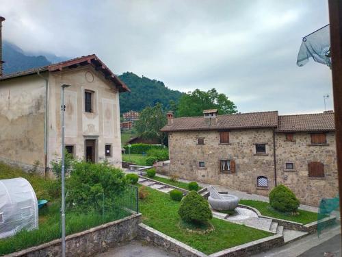 an old stone building with a yard in front of it at Appartamento con la vista in Oltre il Colle