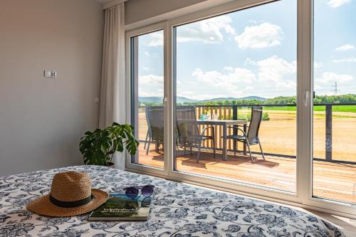 a hat on a table in front of a sliding glass door at Lamelove Apartments - Energylandia, Zator in Chocznia