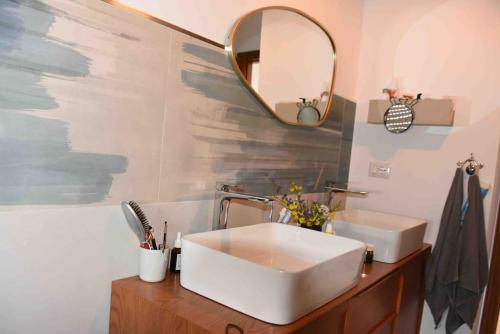 ein Badezimmer mit einem weißen Waschbecken und einem Spiegel in der Unterkunft Casa via Mare in Rocca Imperiale