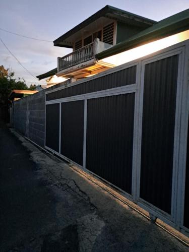 a black fence in front of a house at Laure hébergement chambre tiare in Faaa