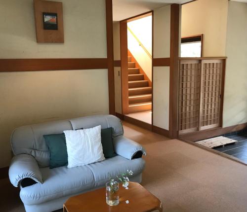 a living room with a couch and a table at Pension Amagiji in Izu