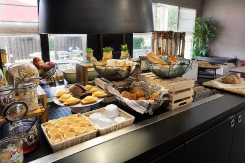 a buffet with many different types of bread and pastries at Hotel Morangis Orly in Morangis