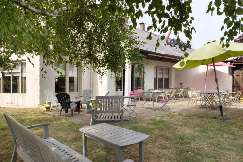 a group of chairs and tables and an umbrella at Hotel Morangis Orly in Morangis