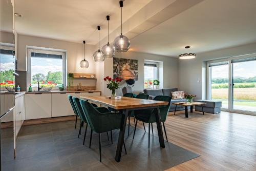 a kitchen and living room with a table and chairs at Lamelove Apartments in Chocznia