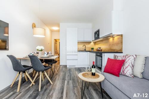 a living room and kitchen with a couch and a table at KORZO LIPNO 2 in Lipno nad Vltavou