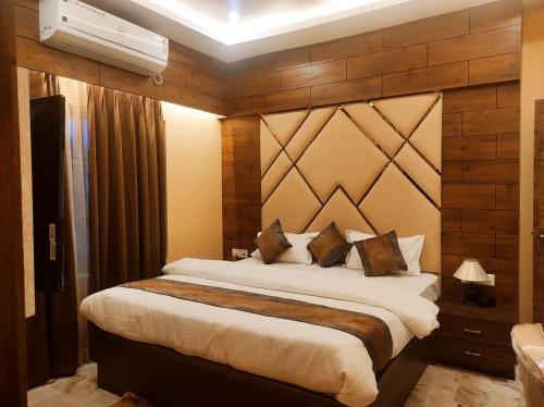 1 dormitorio con 1 cama grande y pared de madera en Hotel Friends Palace, en Tezpur