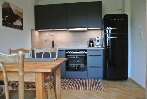 a kitchen with a table and a black refrigerator at Appartement Seespitzhof in Scheffau am Wilden Kaiser